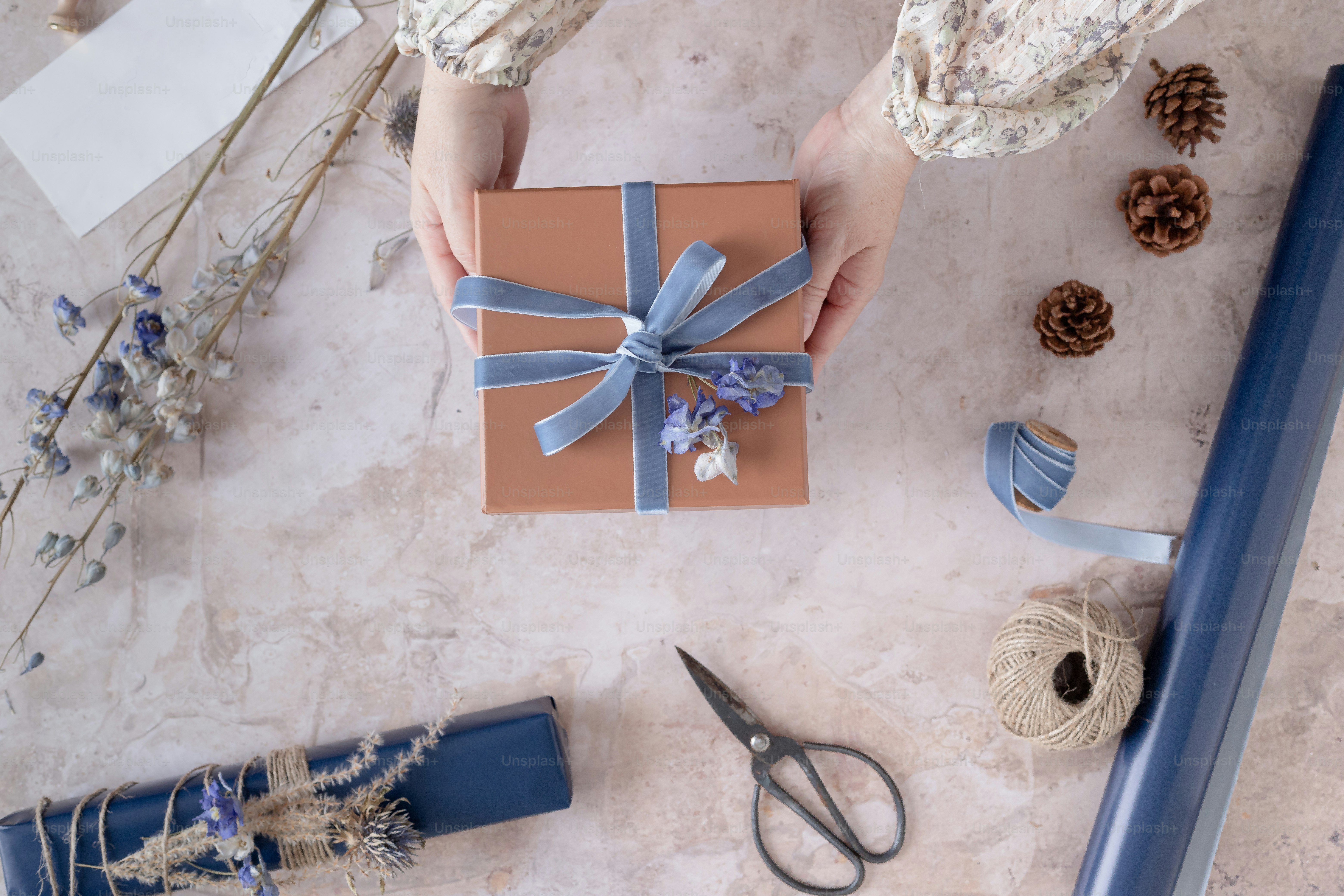 A woman holding a gift box with a blue ribbon photo Wrapping gifts