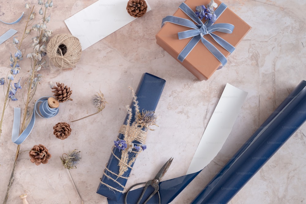 a table topped with blue wrapping paper and a pair of scissors