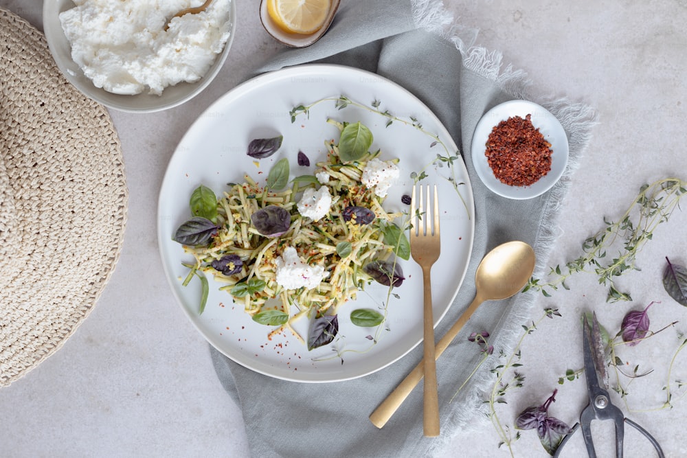 ein weißer Teller mit einem Salat neben einer Schüssel Reis