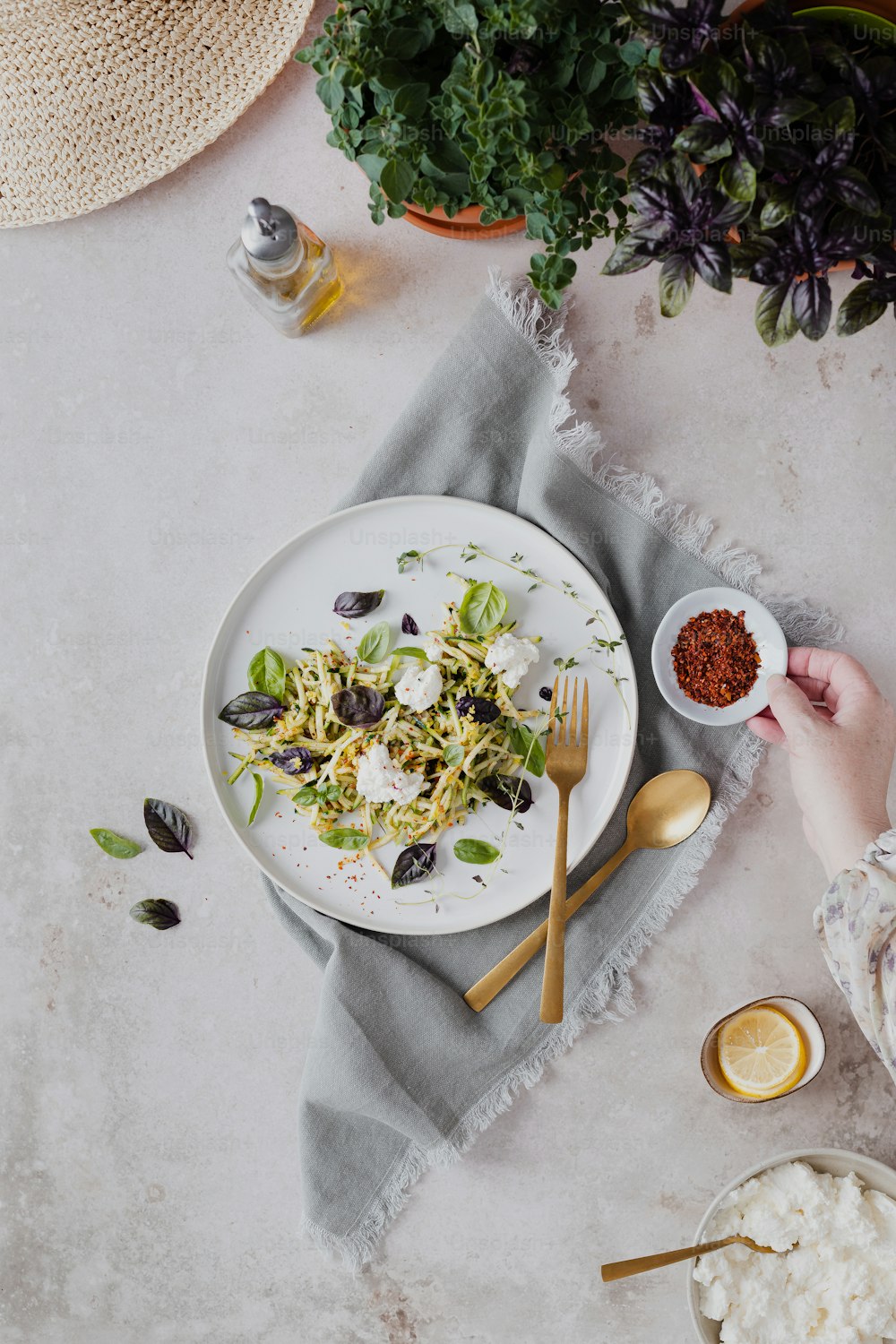 a white plate topped with a salad next to a bowl of salad