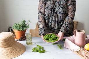 a woman holding a bowl of green beans