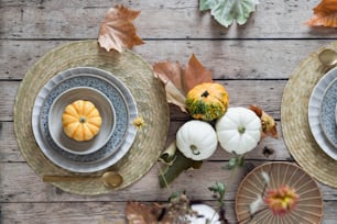 a table topped with plates and bowls filled with pumpkins