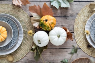 a table topped with plates and bowls filled with pumpkins