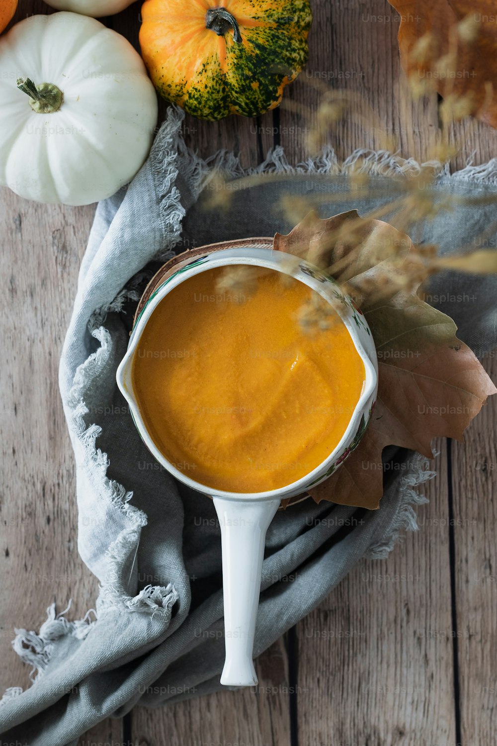 a bowl of pumpkin dip surrounded by pumpkins