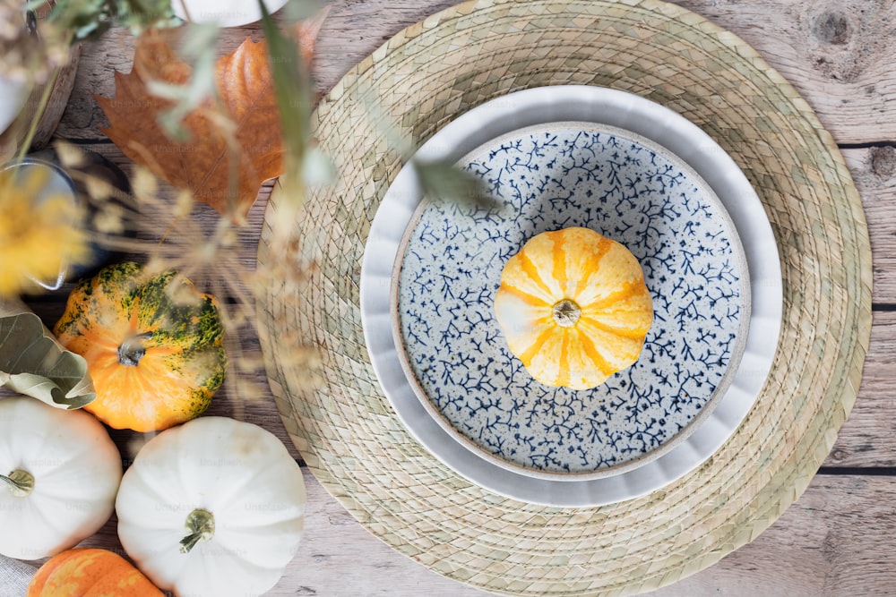 a blue and white plate topped with a yellow pumpkin