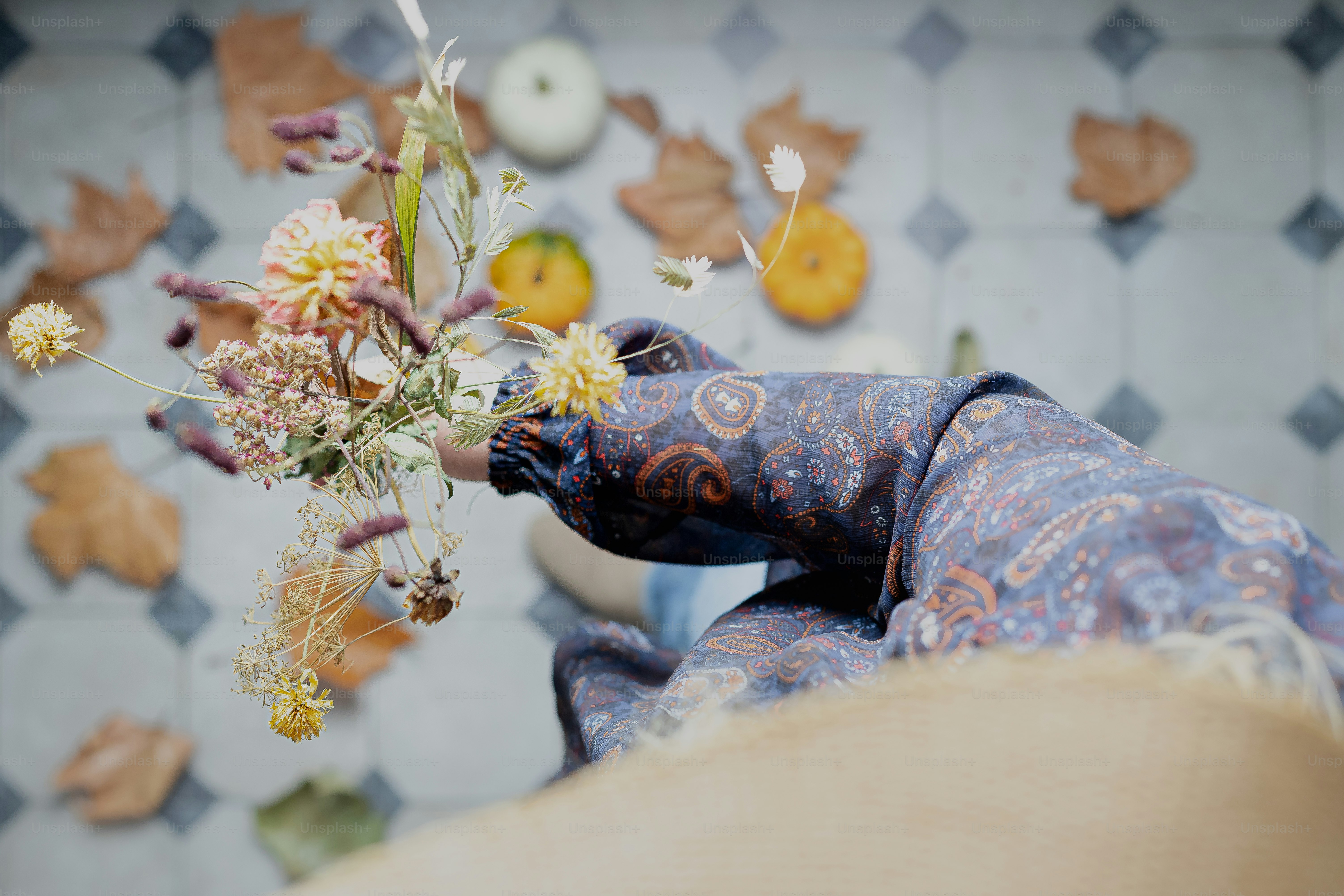 un gros plan d’une personne tenant un bouquet de fleurs