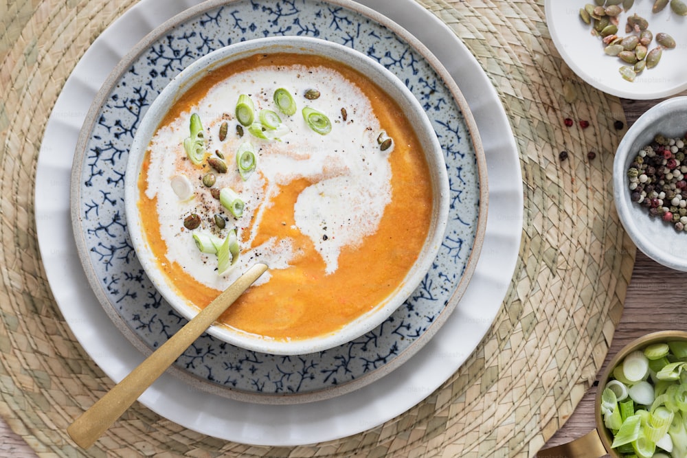 a bowl of carrot soup with a spoon in it