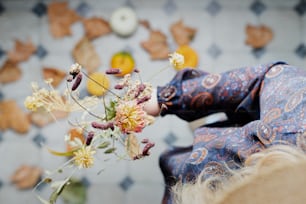 a close up of a person holding a vase with flowers
