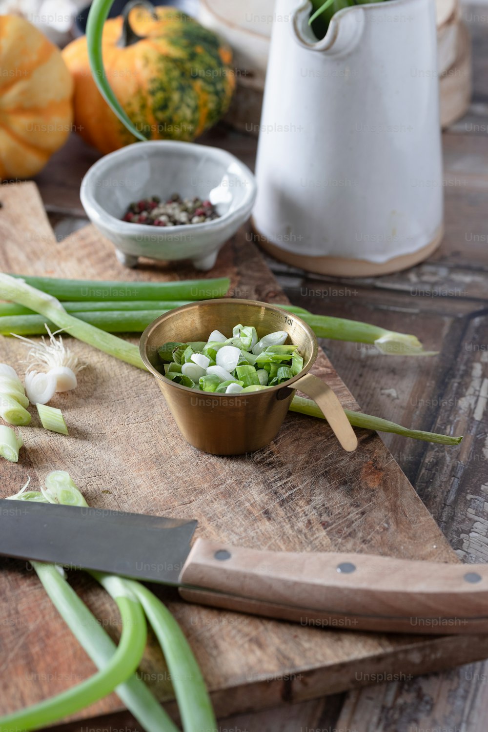 a wooden cutting board topped with green onions