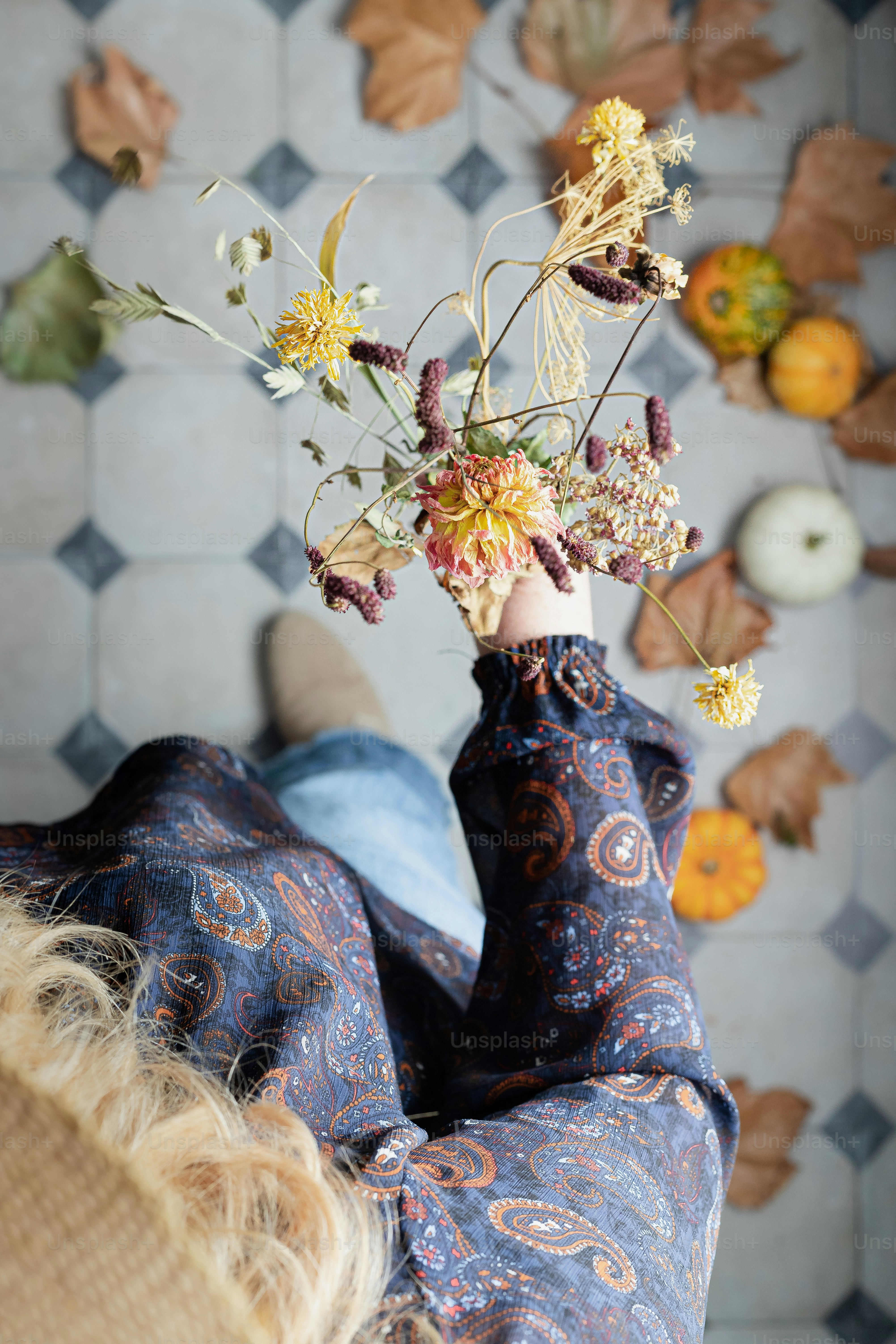 Une femme allongée sur un canapé avec un vase de fleurs à la main