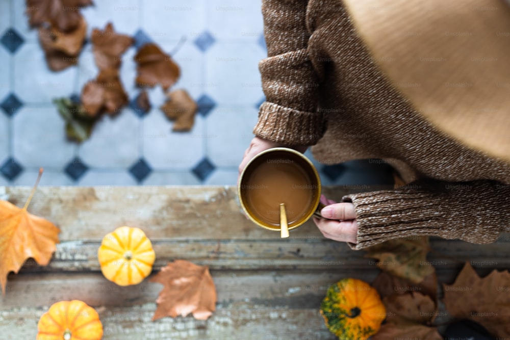 a person holding a cup of coffee in their hand