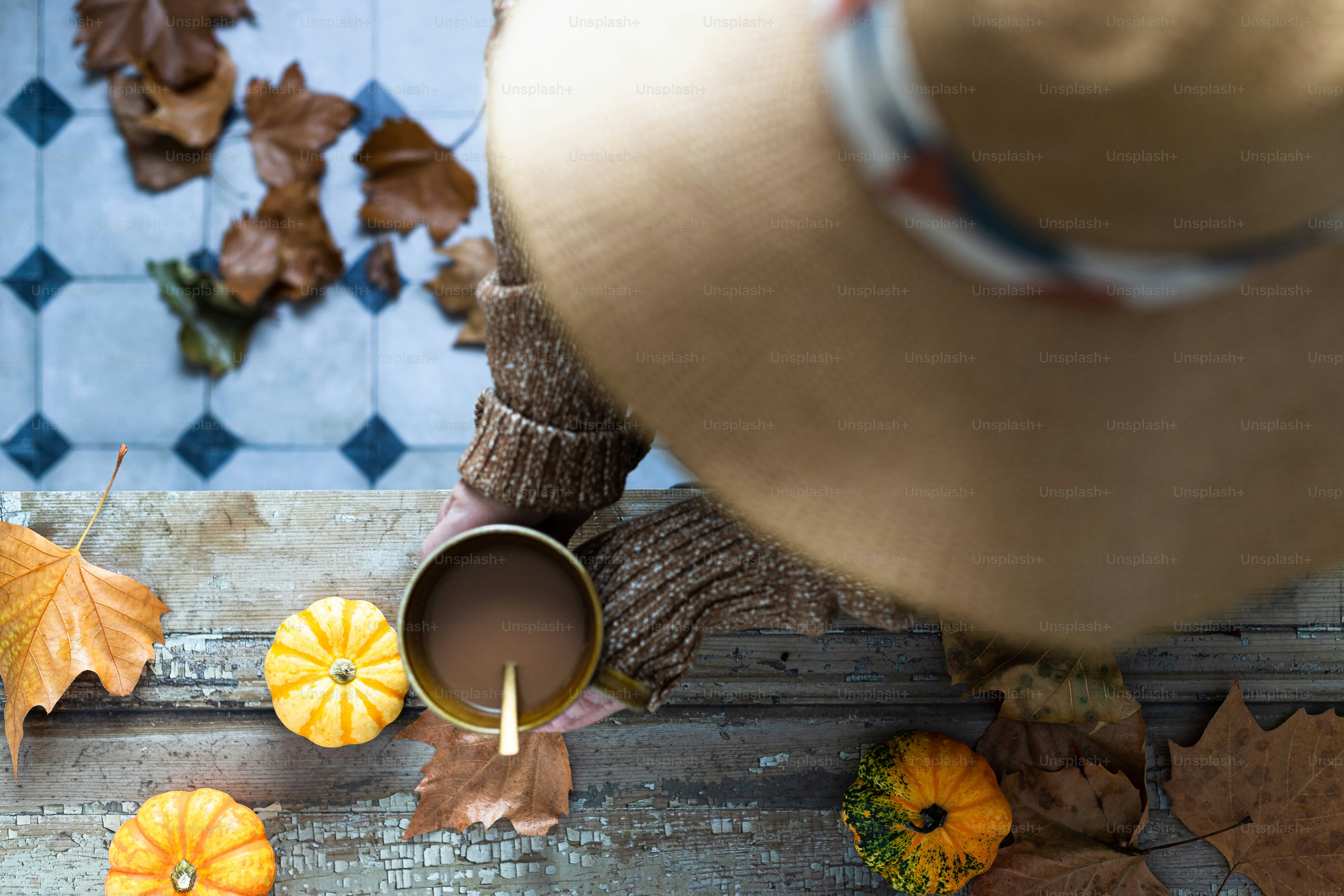 A person holding a cup of coffee in front of fall leaves photo – Autumn ...