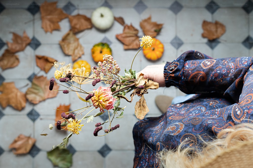 uma mulher segurando um ramo de flores na mão