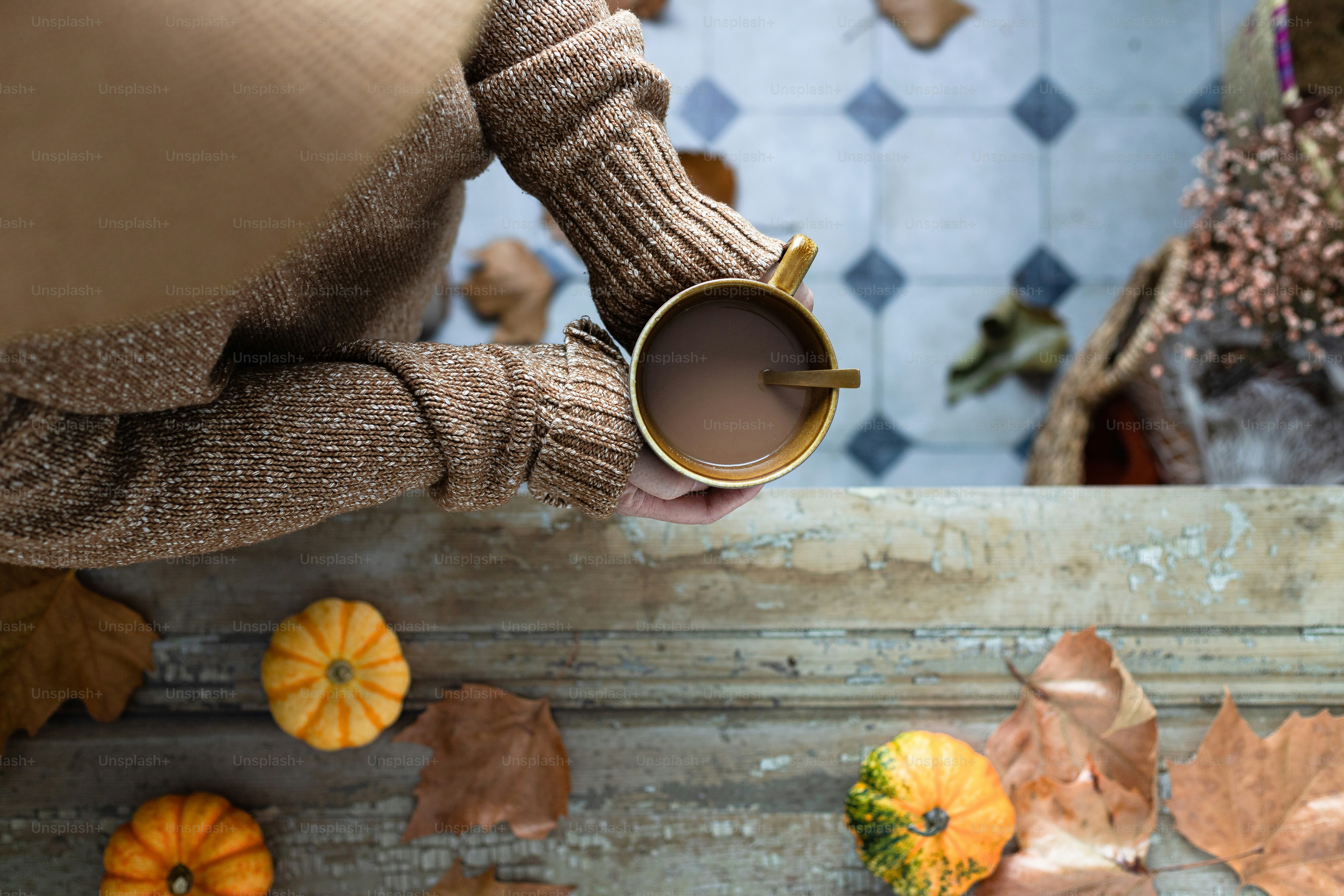 eine Person, die eine Tasse Kaffee in den Händen hält