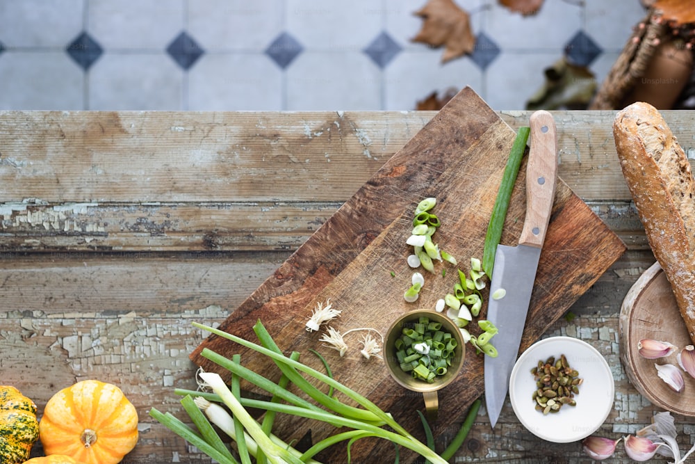 a wooden cutting board topped with vegetables next to a knife