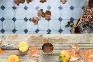 a cup of coffee sitting on top of a wooden table