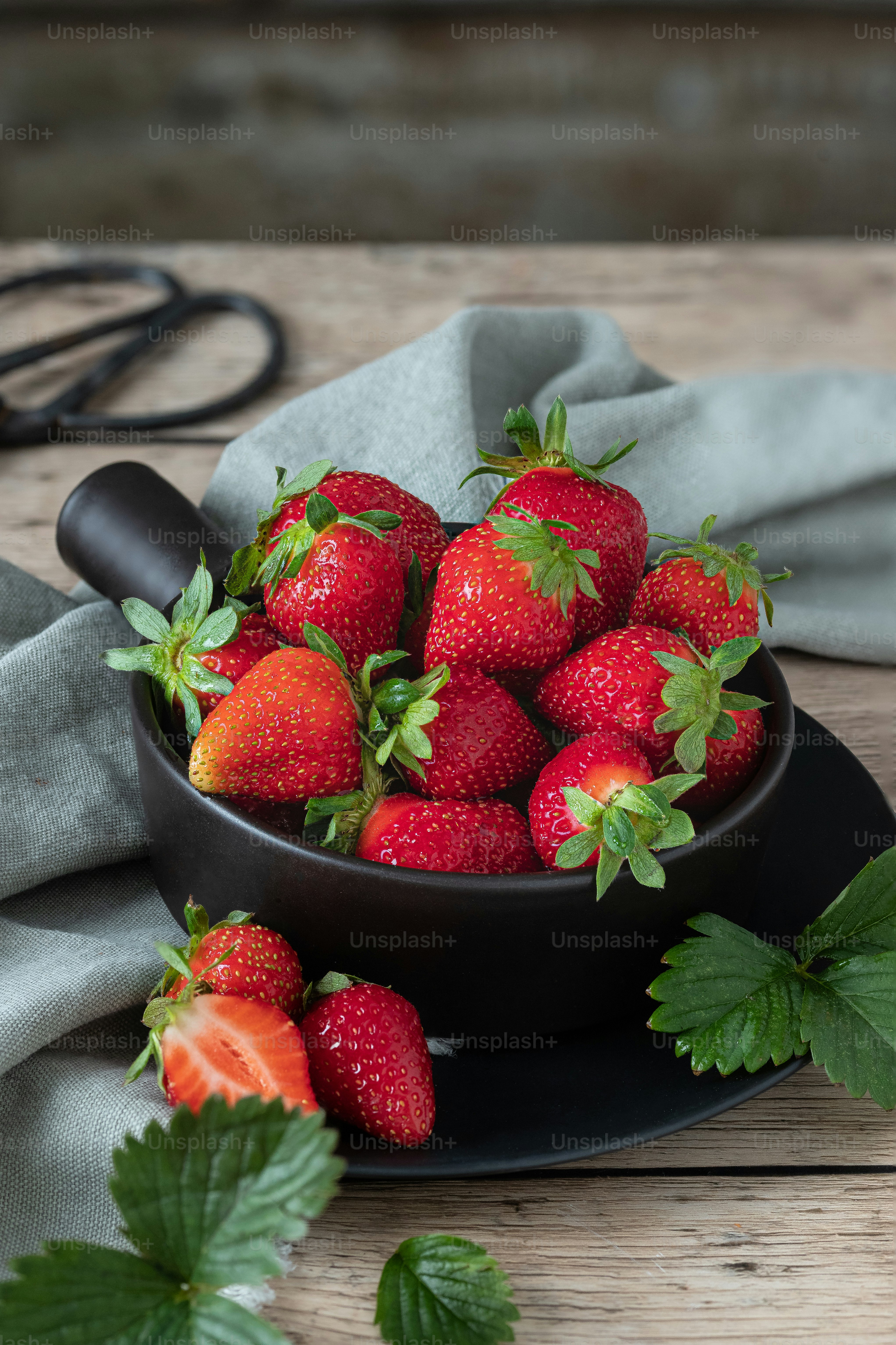 A bowl full of strawberries on a table photo – Bowl of strawberries ...
