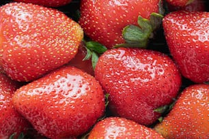 a close up of a pile of ripe strawberries