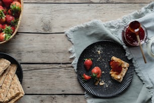 a plate of strawberries next to a bowl of strawberries