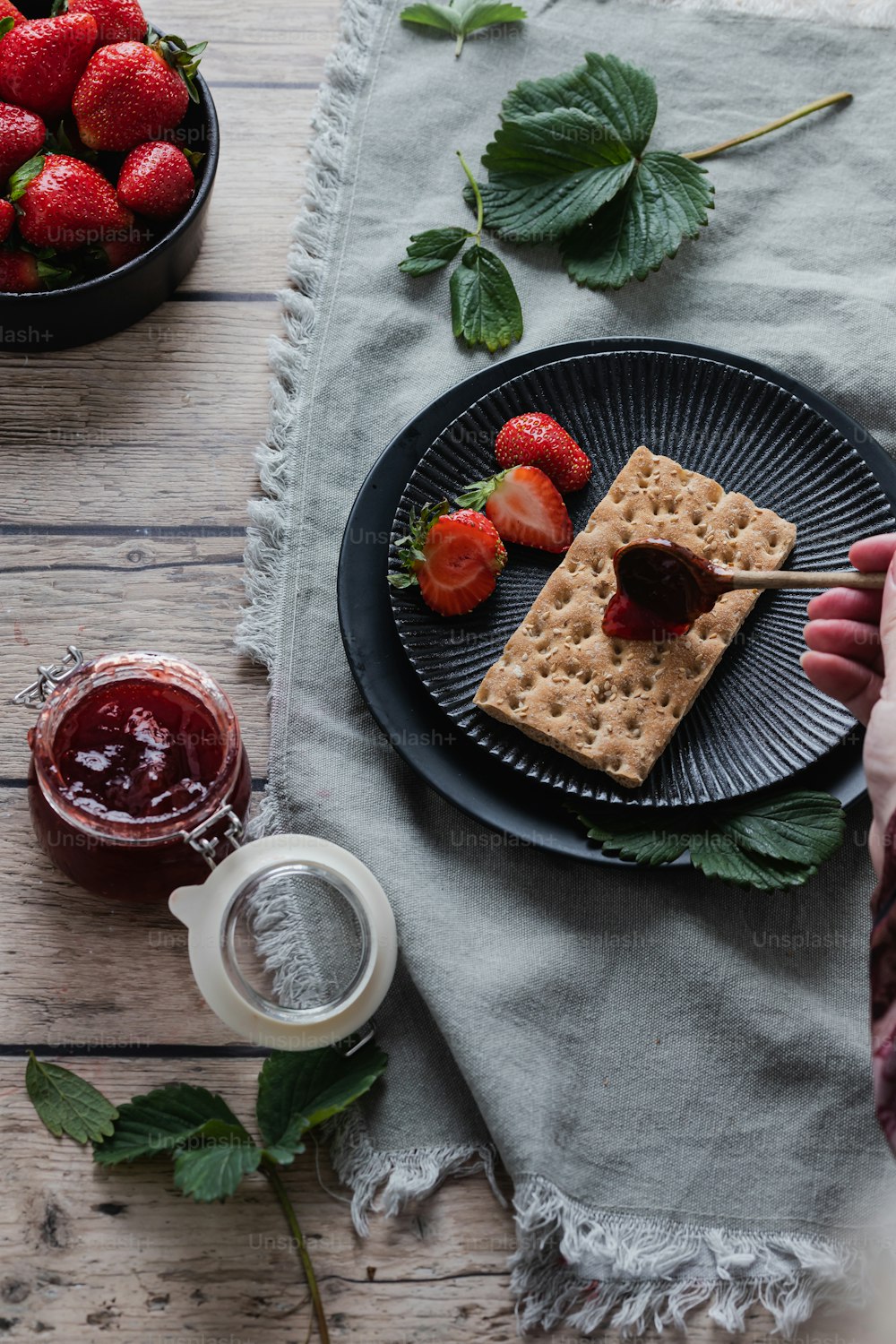 a plate of strawberries and crackers on a table