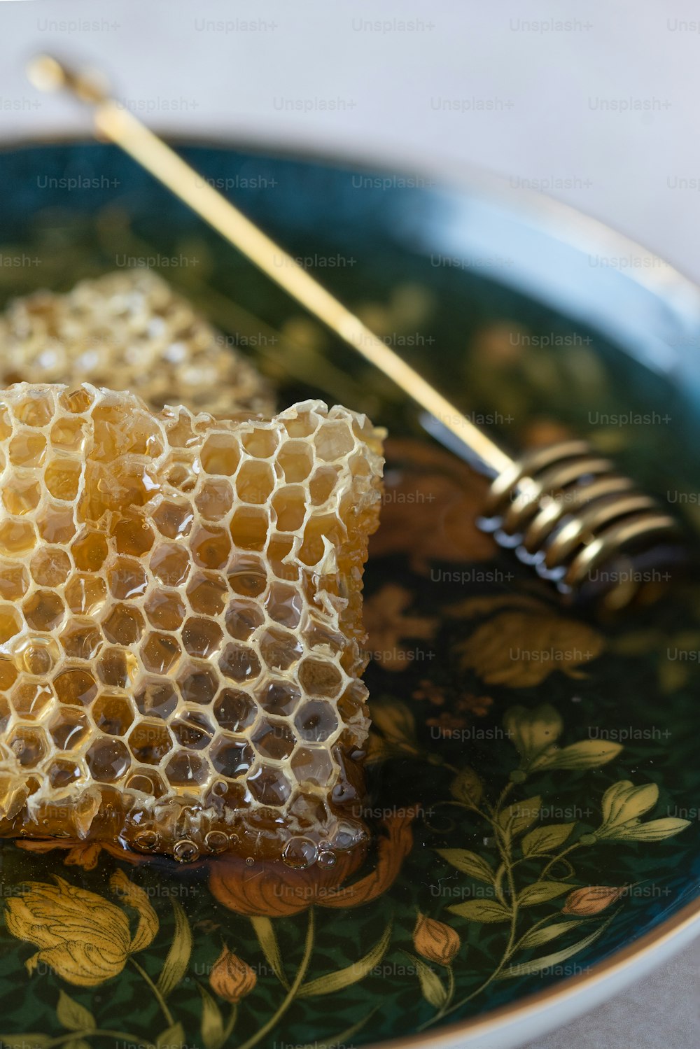 a piece of honey on a plate with a honey comb
