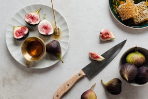 a white plate topped with figs next to a knife