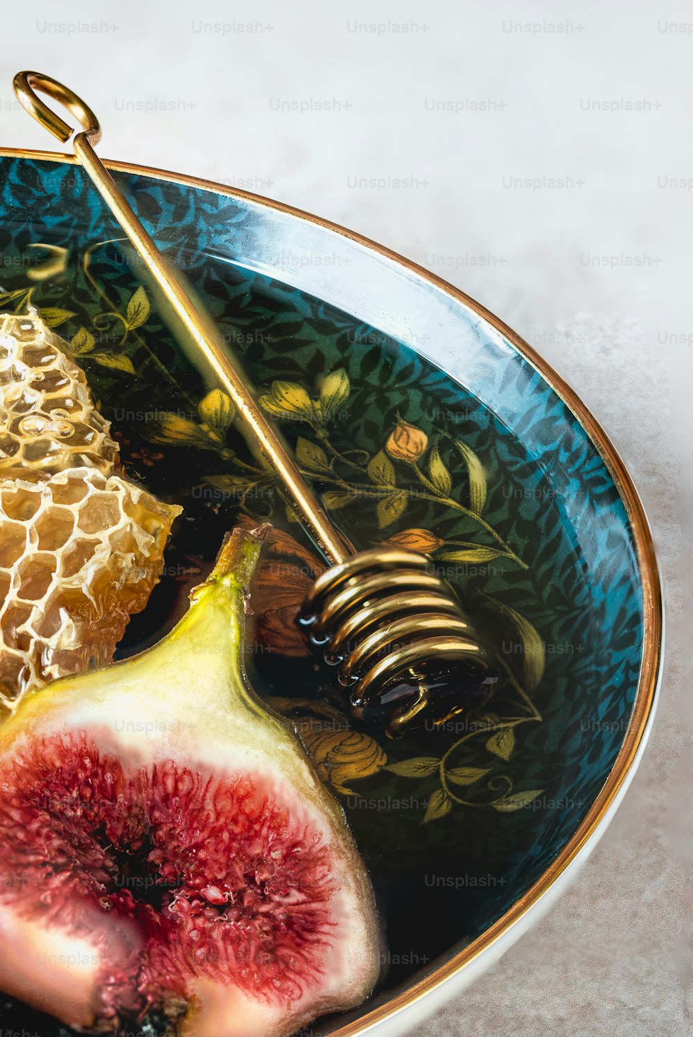 a bowl filled with figs and honey on top of a table
