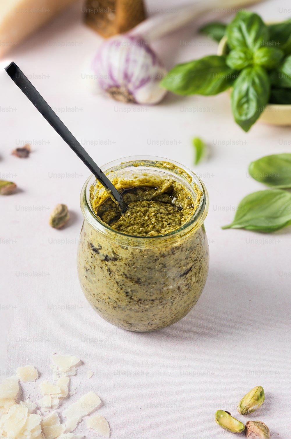 a jar of pesto sauce with a spoon in it