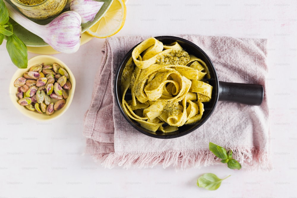 a bowl of pasta with pesto and sunflowers