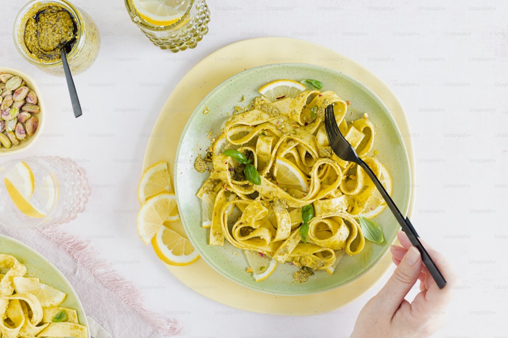 a plate of pasta with lemons and pesto
