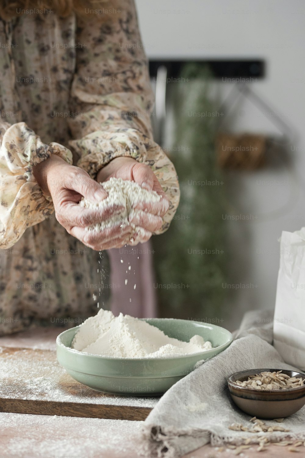 a woman is sprinkling flour into a bowl