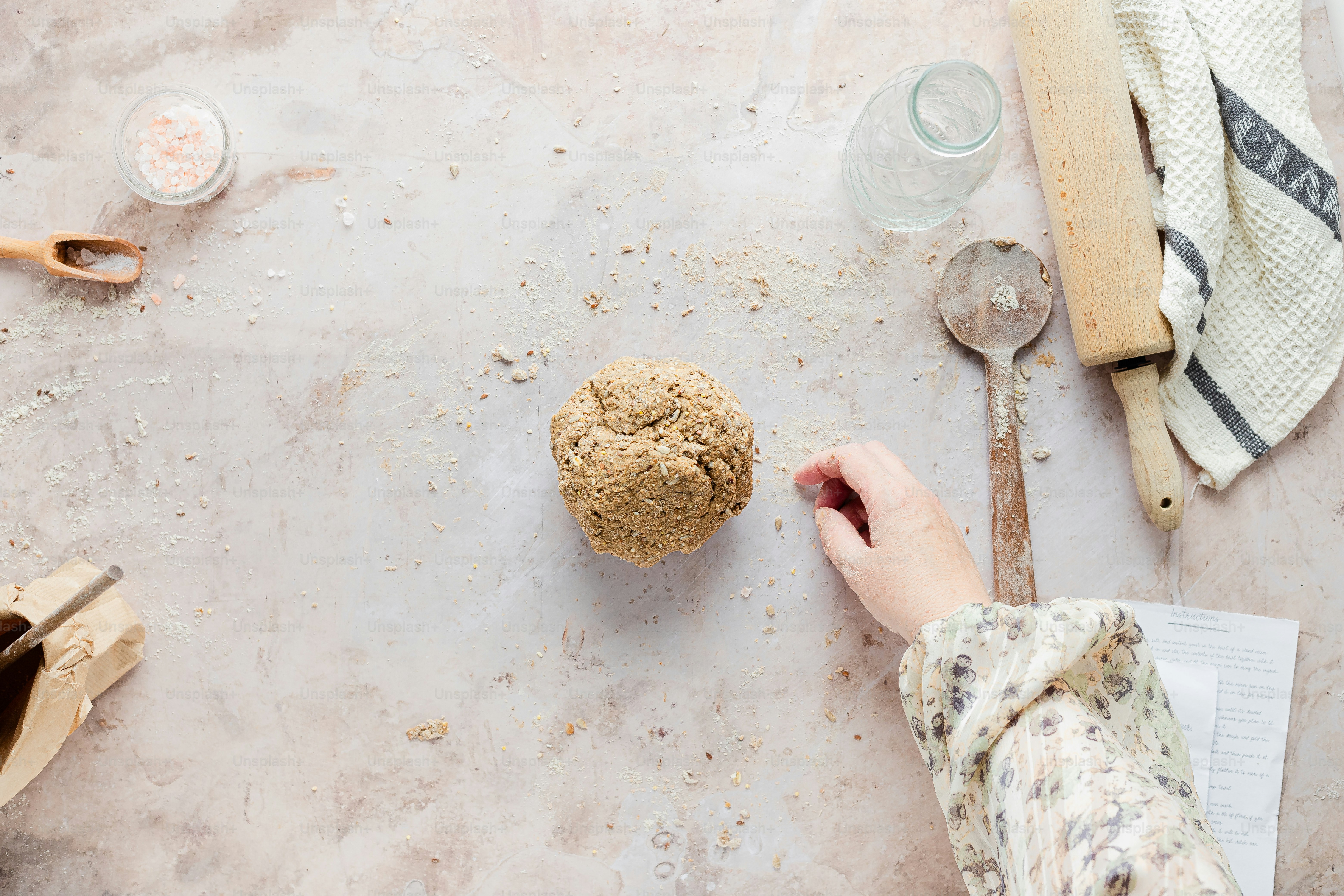 a person holding a spoon near a cookie on a table