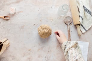 a person holding a spoon near a cookie on a table