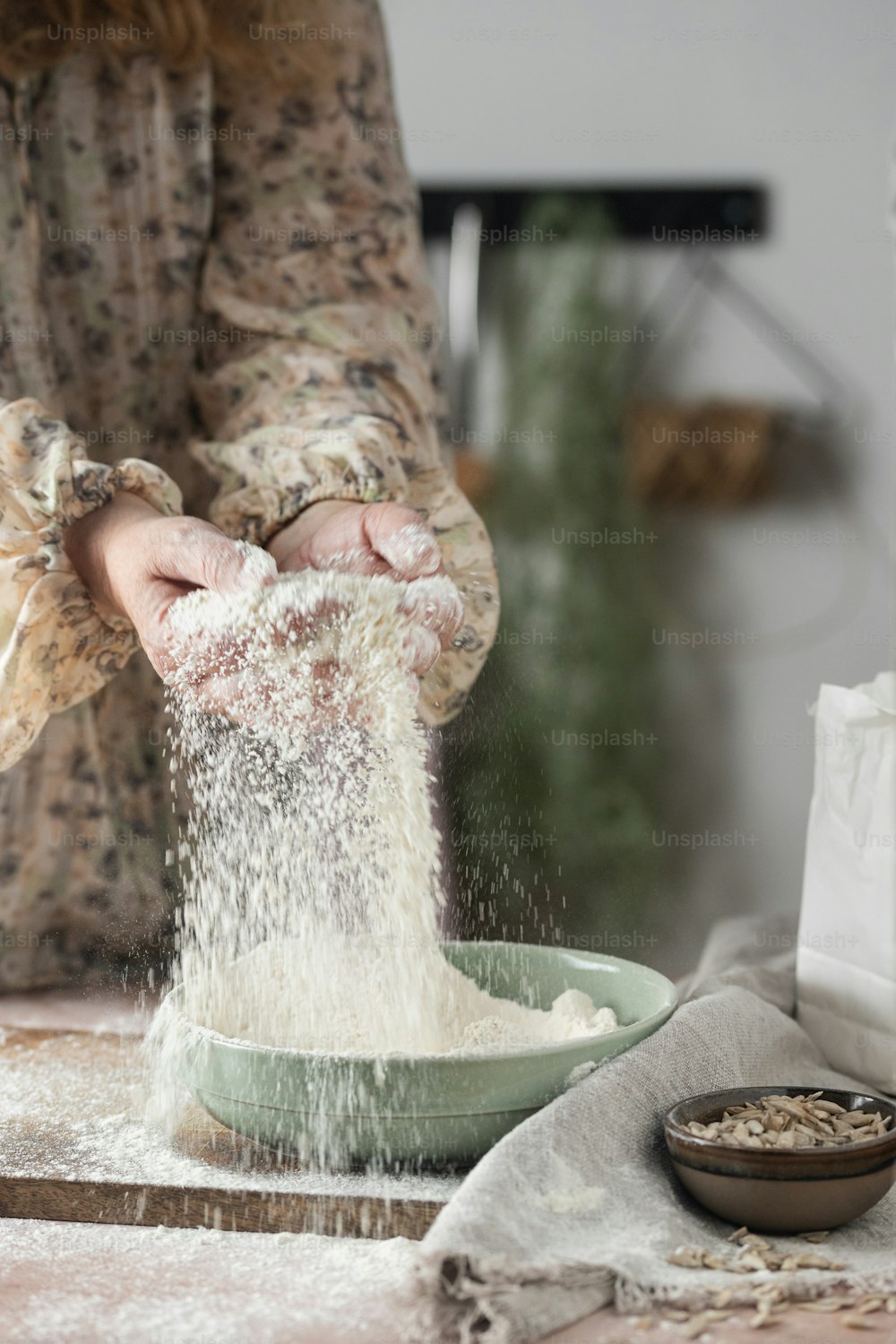 a woman is sprinkling flour into a bowl