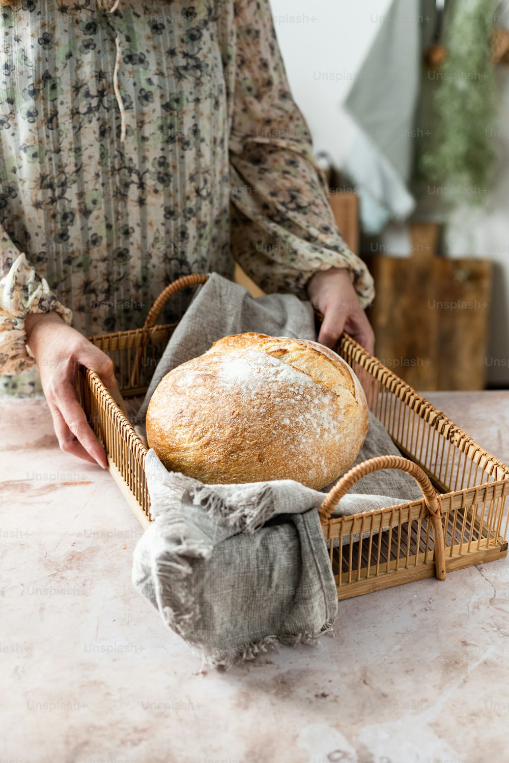 Una mujer sosteniendo una barra de pan en una canasta