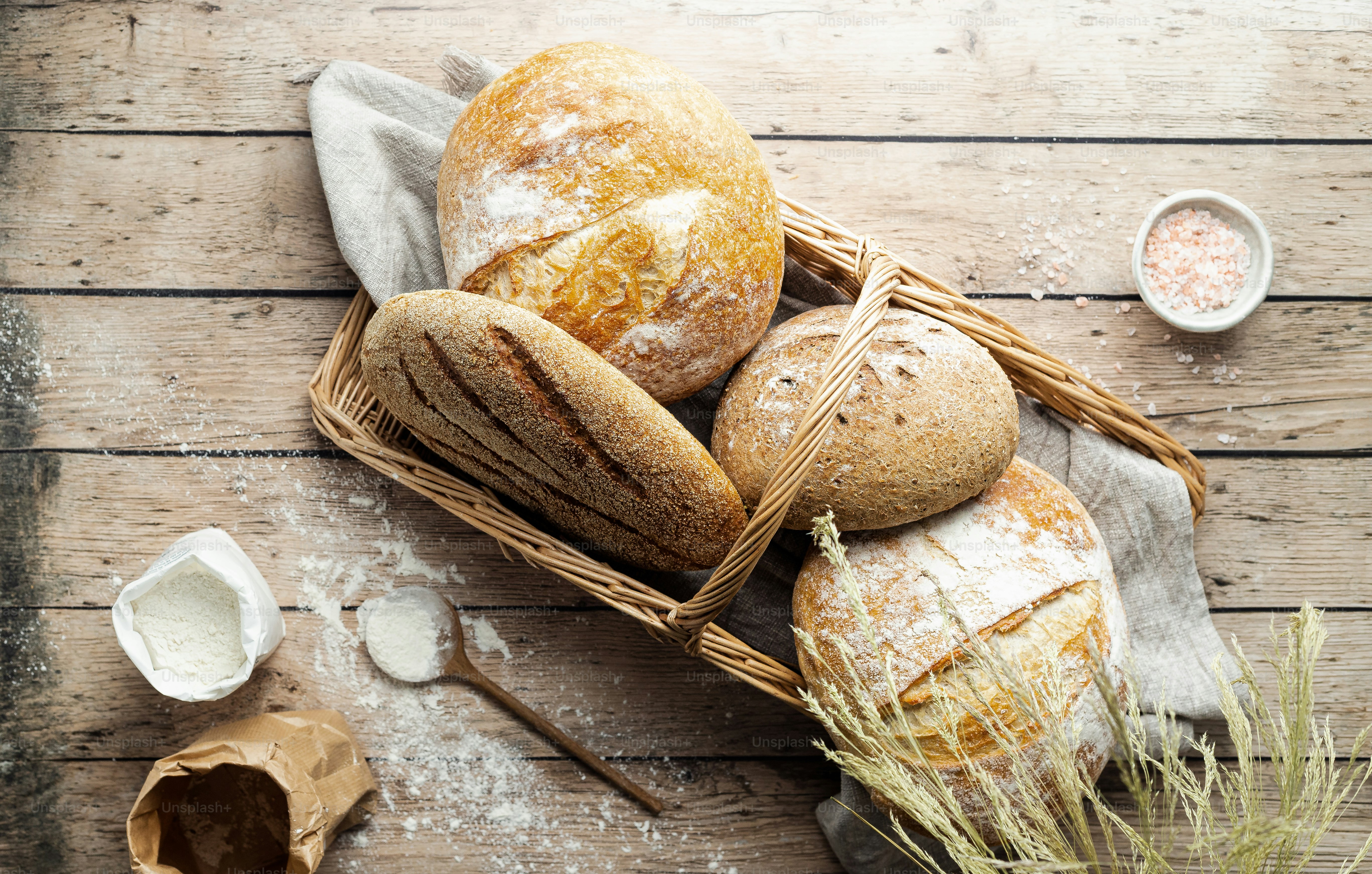 a basket filled with loaves of bread on top of a wooden table