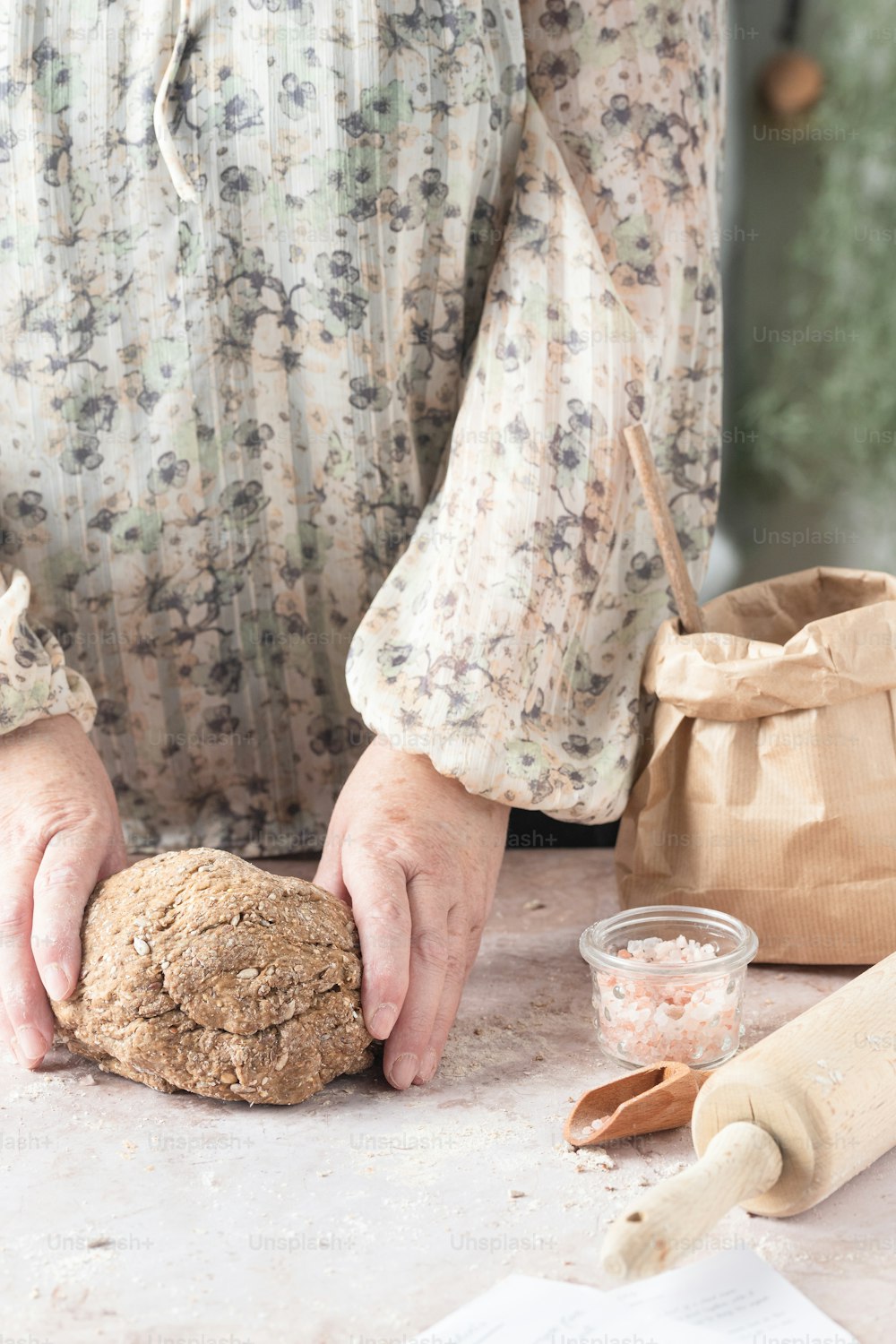 a person holding a loaf of bread on top of a table