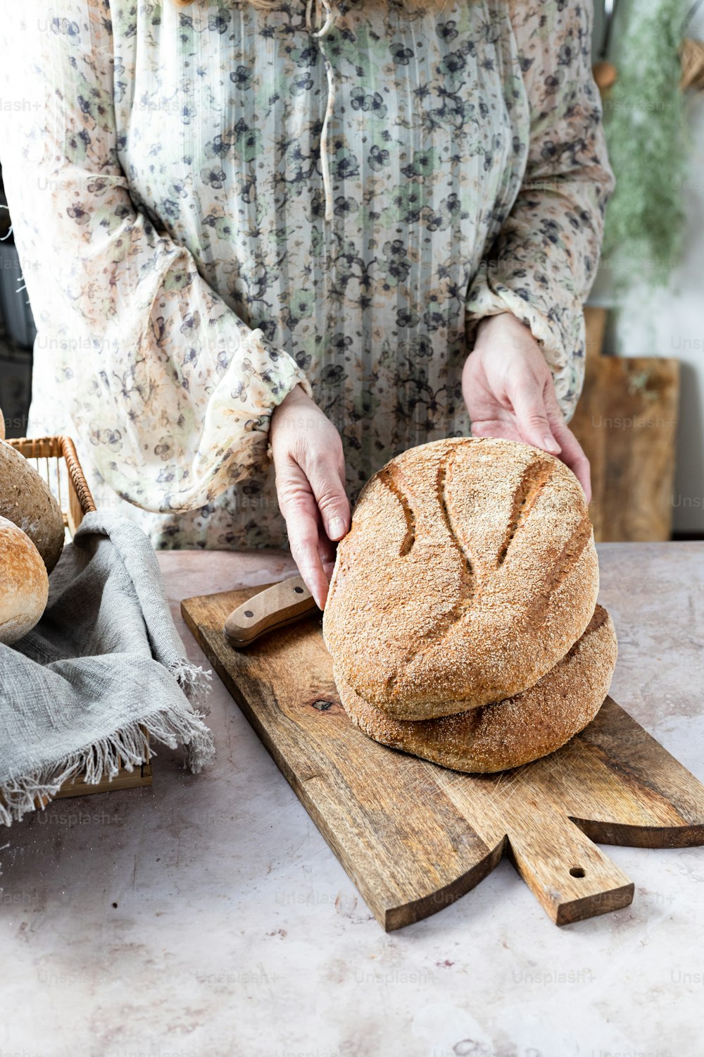 Una mujer está haciendo pan en una tabla de cortar