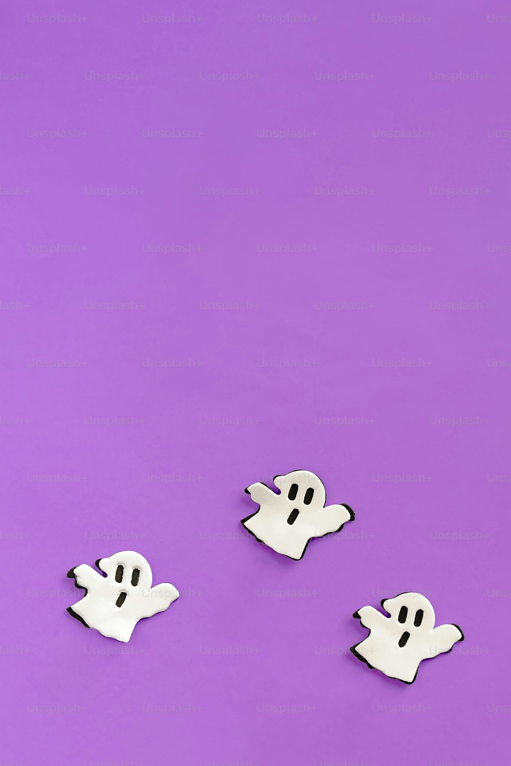 a group of ghost pins sitting on top of a purple surface