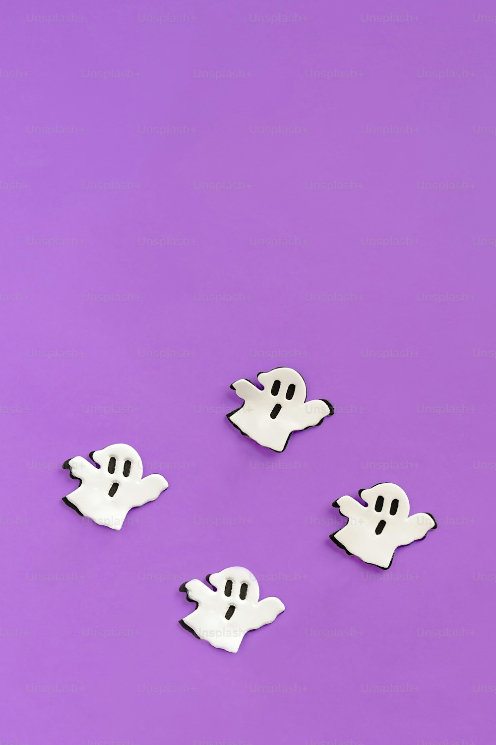 Un grupo de botones fantasma sentados encima de una superficie púrpura
