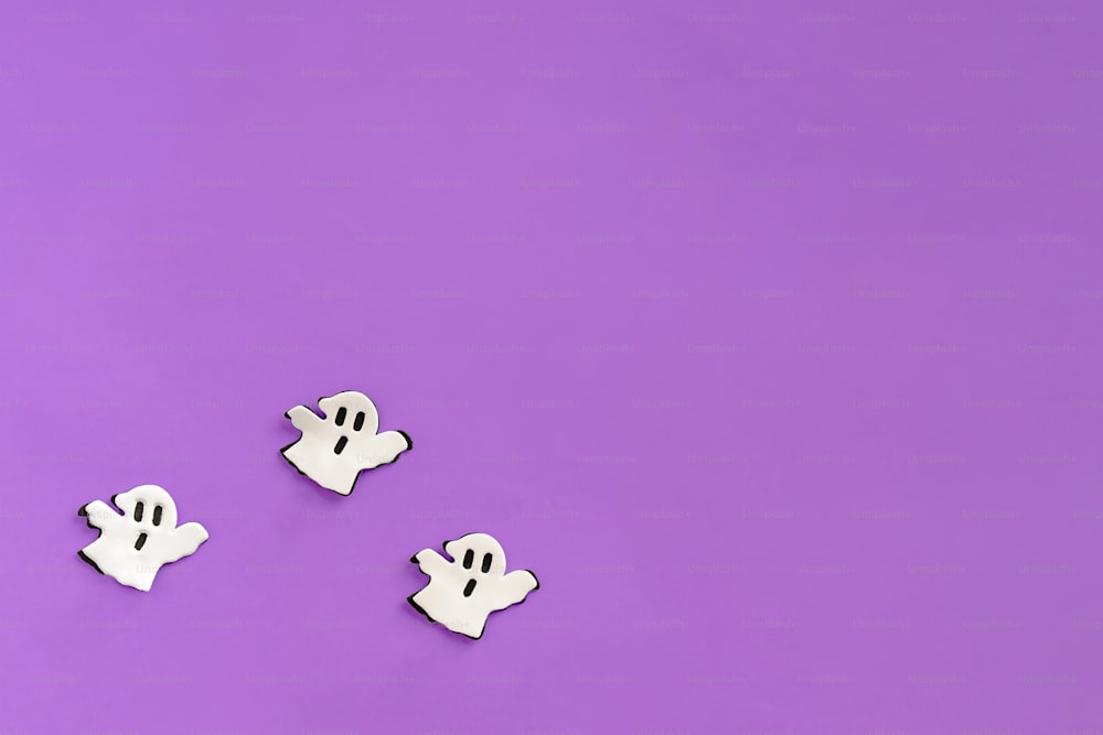 three white ghost magnets on a purple background