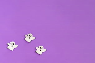 three white ghost magnets on a purple background