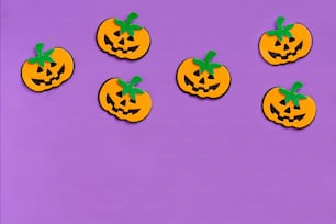a group of pumpkins sitting on top of a purple surface