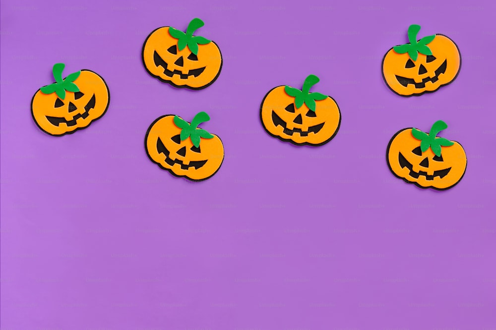 a group of pumpkins sitting on top of a purple surface