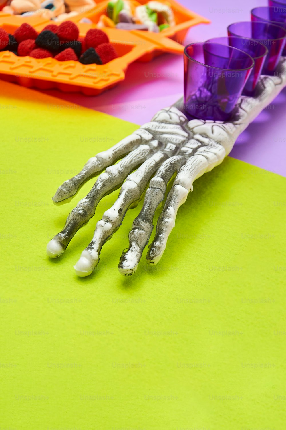 a skeleton hand is on a table with a plate of fruit