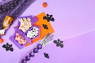 Una mesa púrpura cubierta con muchas golosinas de Halloween