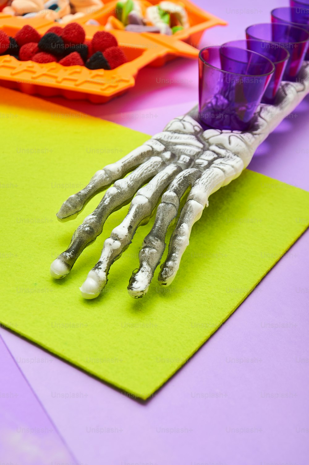 a skeleton hand on top of a green piece of paper
