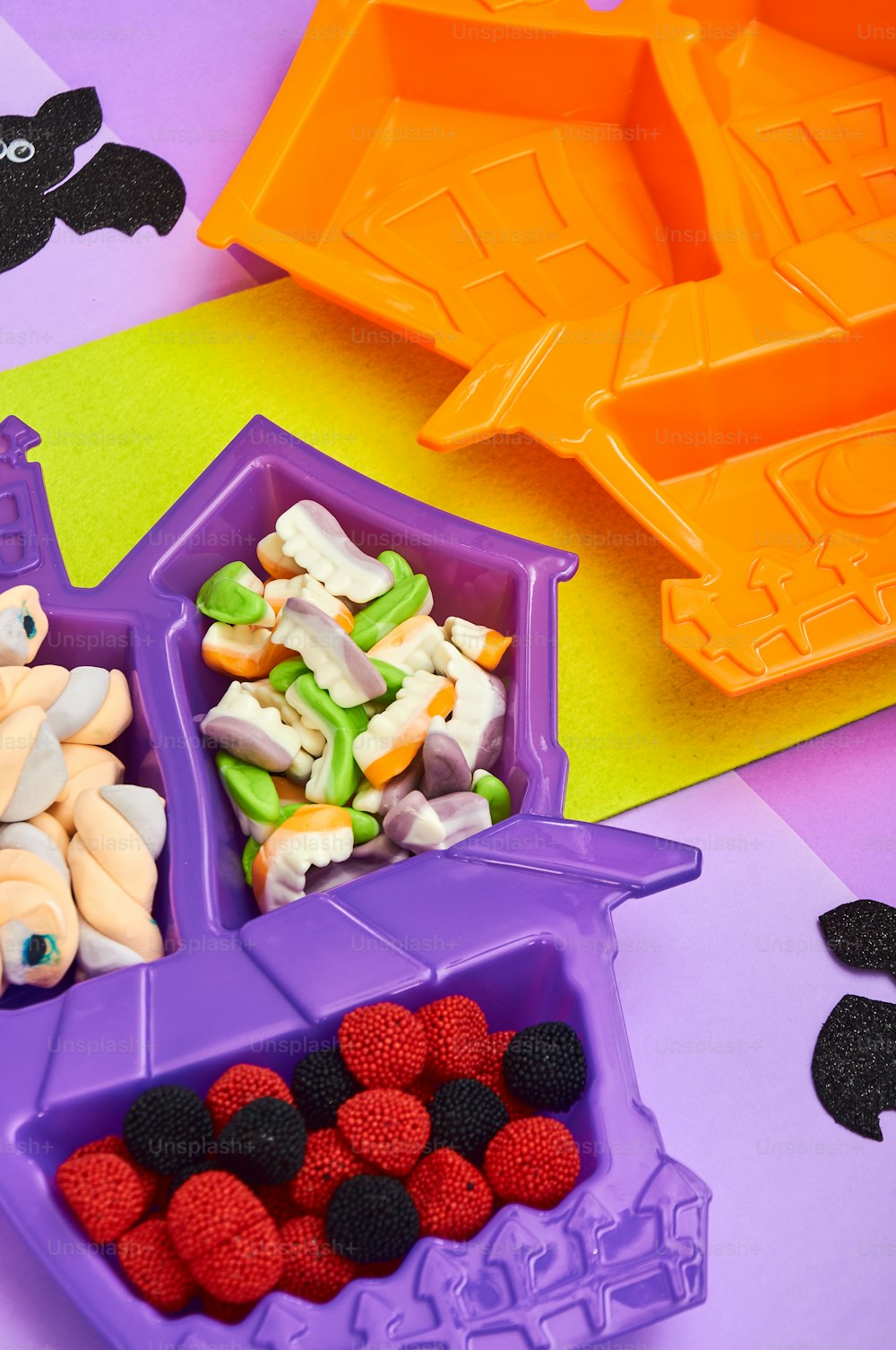 a purple container filled with fruit next to a purple container filled with candy