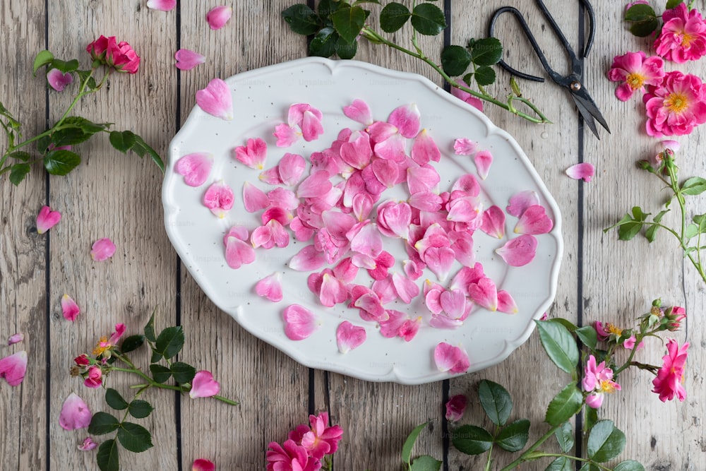 a white plate with pink flowers on a wooden table