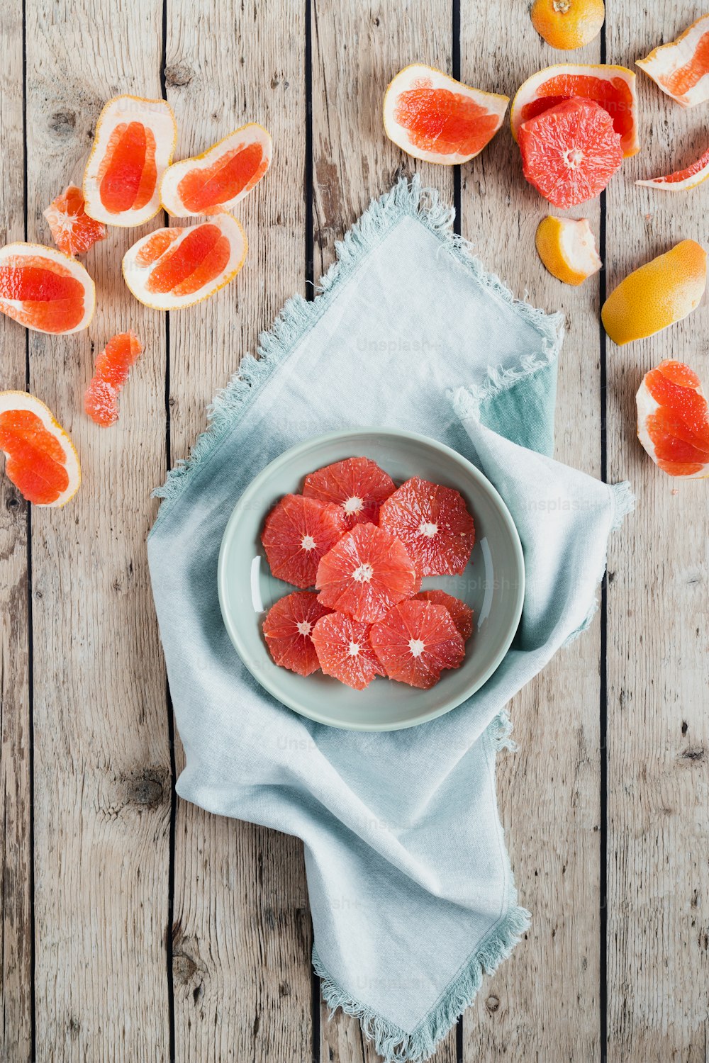 a plate of sliced grapefruits on a wooden table